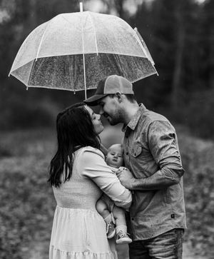 Family posing with an umbrella black and white