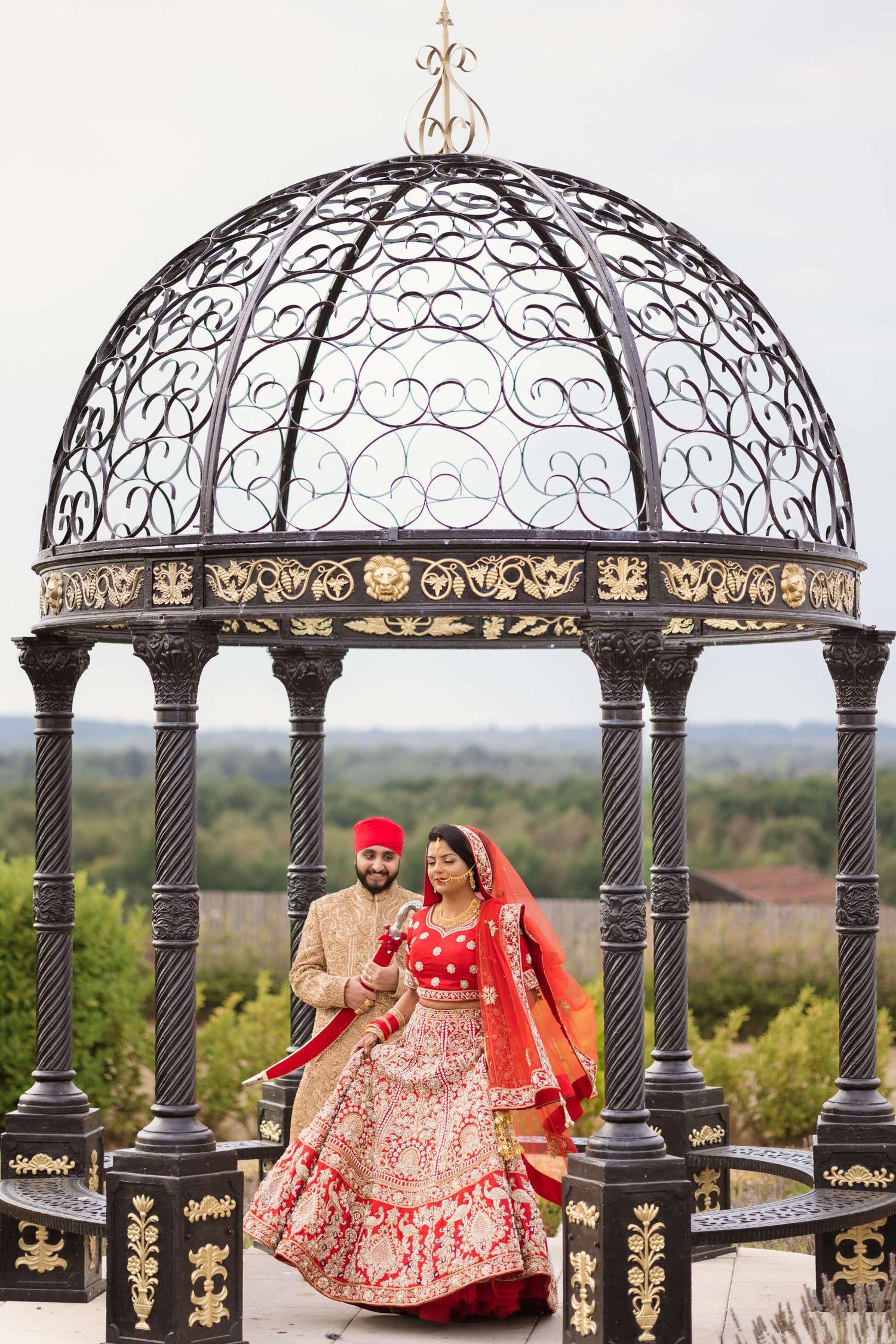 Joyful newly weds expressing intimate love captured by the photographers camera, Holding a red kirpan