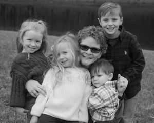 A black and white photo collage showing candid family moments of children playing and embracing outdoors.