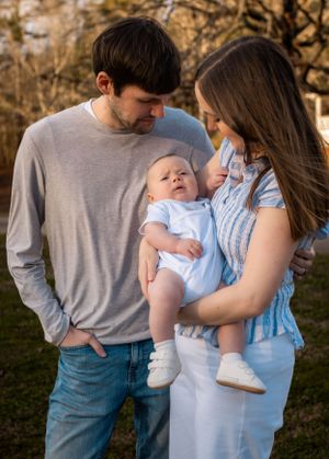 Family sharing intimate moment together during outdoor sunset photoshoot.