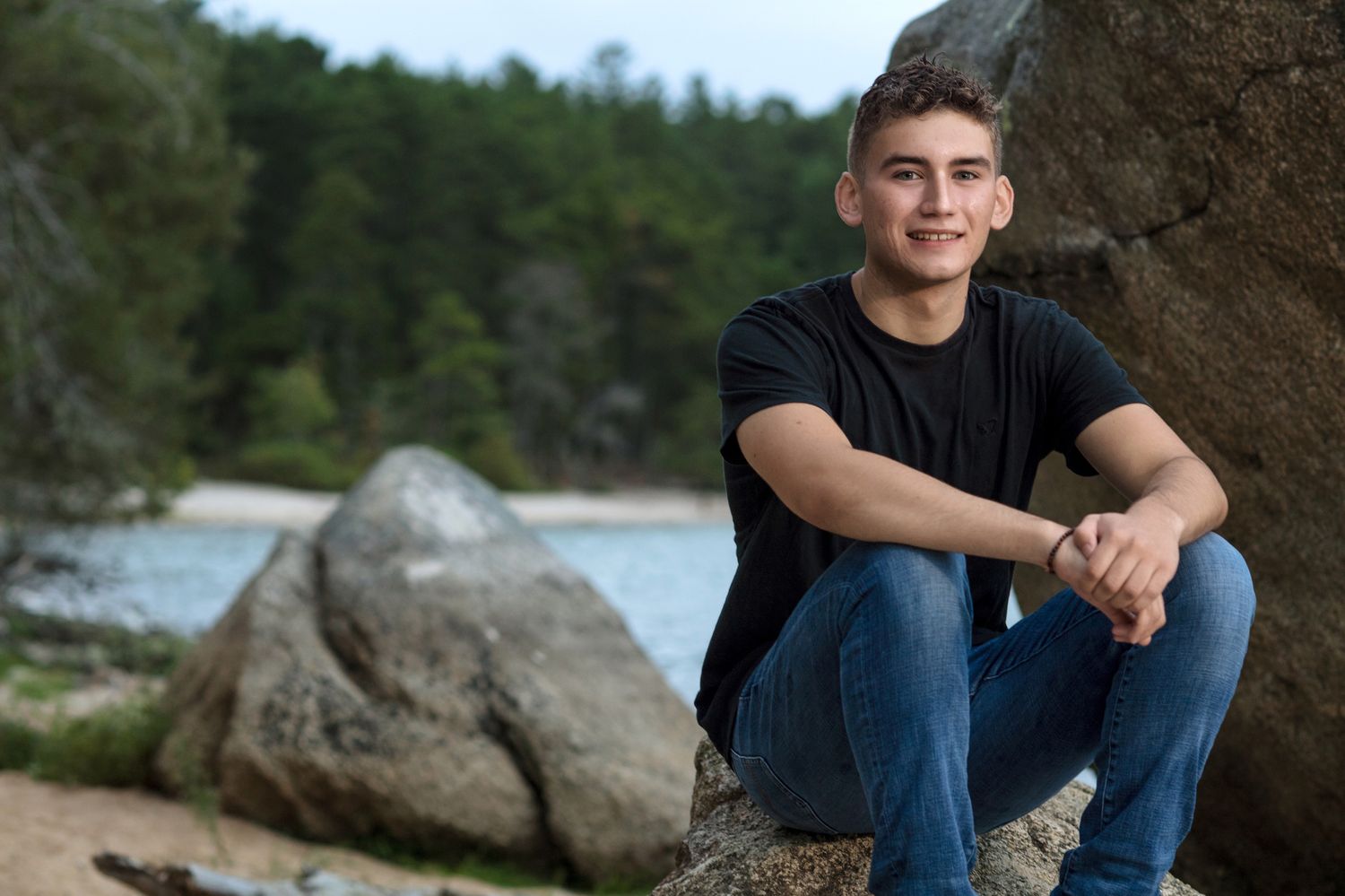 Senior portrait session at a rocky lakeside location.