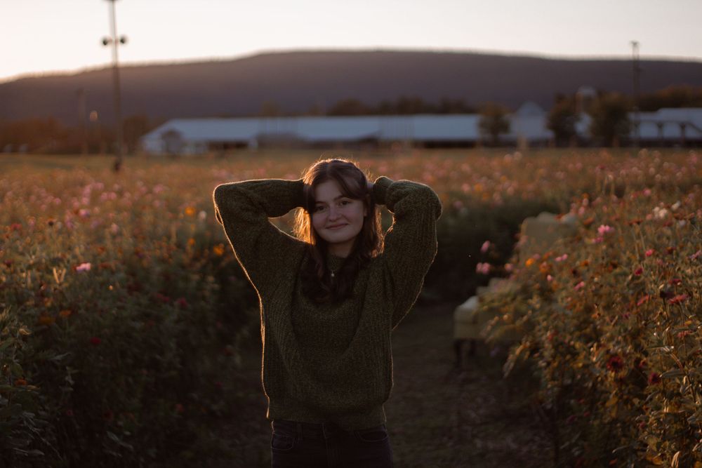 Twilight photo session among tall grass and wildflowers with mountains in the background.