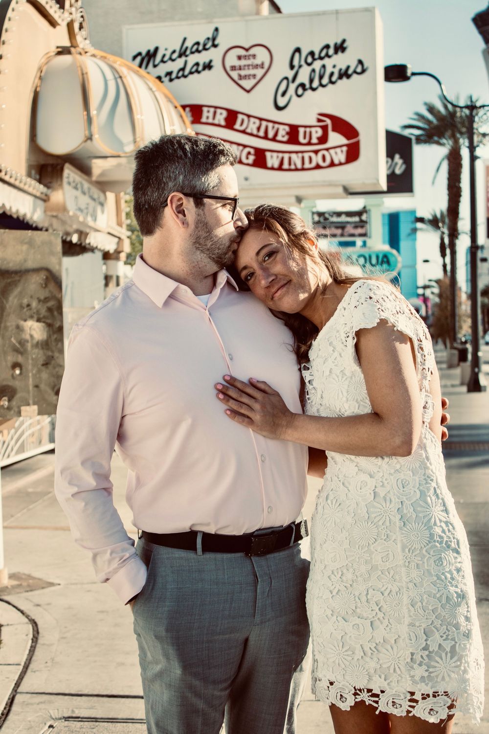 Newlyweds embracing outside A Little White Chapel on the Las Vegas Strip in wedding attire.