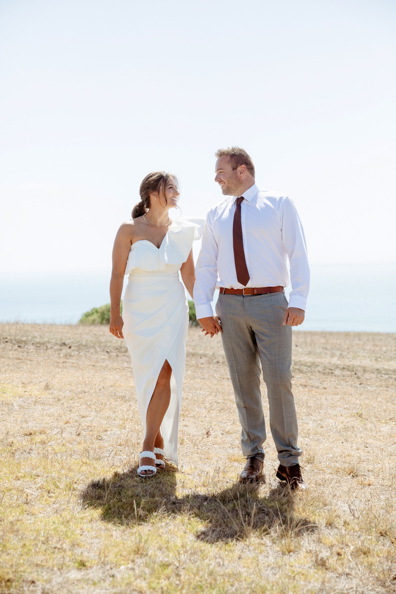 Couple holding hands looking at each other in a field at Jack Rabbit Winery, Bellarine, Victoria
