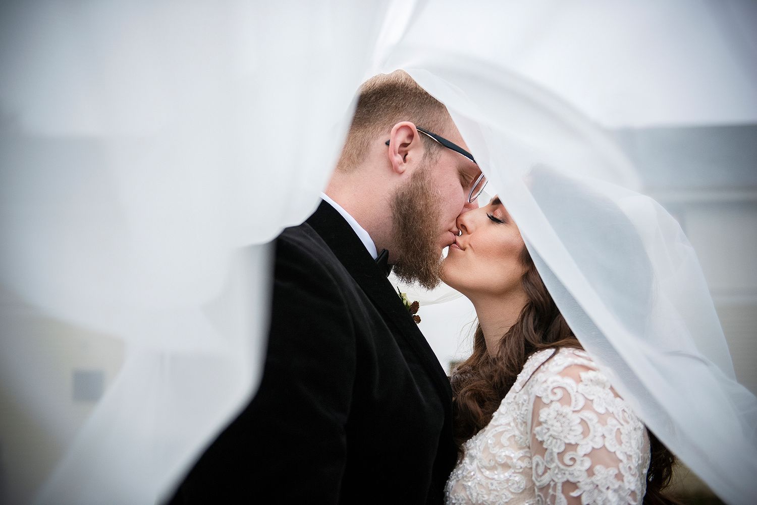 Bride and Groom kissing under a veil at Briar Barn Inn.