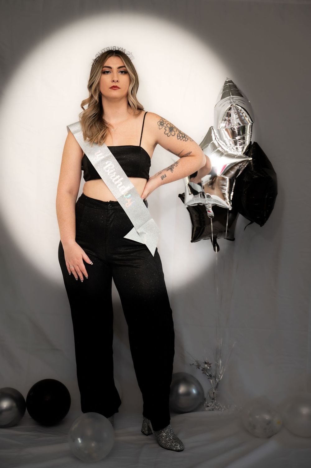 Studio portraits featuring black attire and silver decorative elements against a grey backdrop.