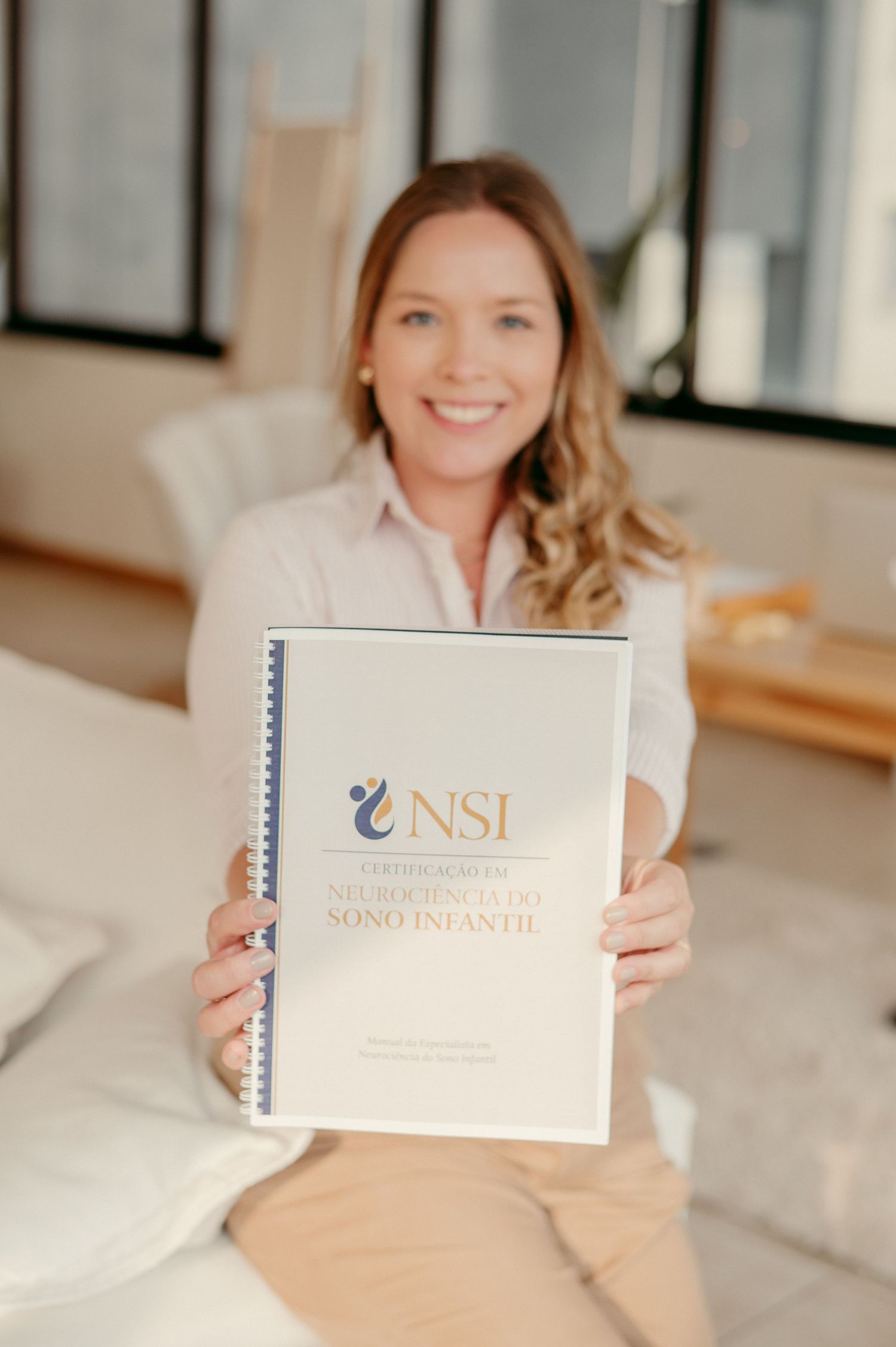 Woman displays NSI branded business document while sitting at desk in bright office setting.