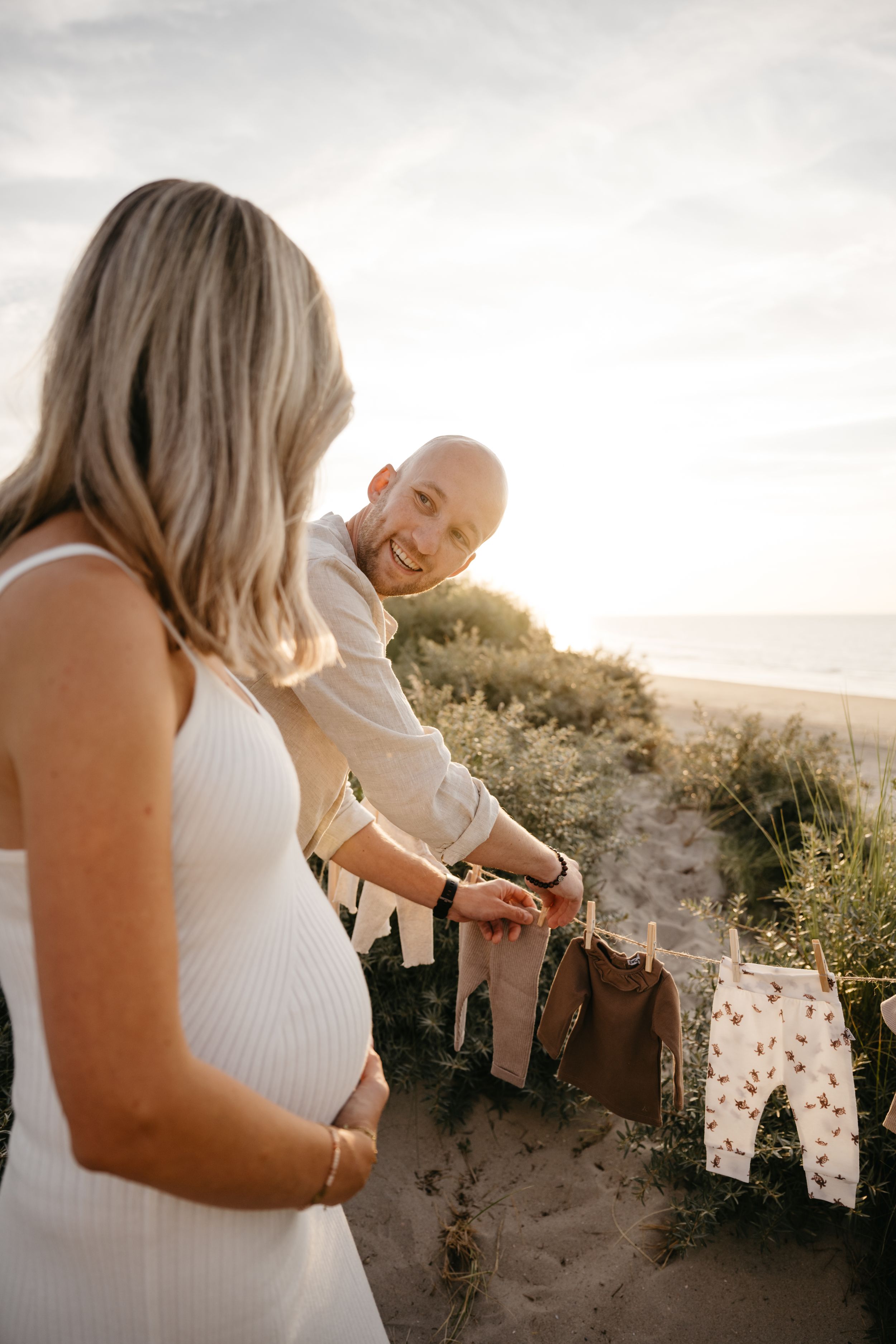 Zwangerschap shoot op het strand tijdens golden hour tussen de duinen