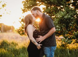 Romantic couple embraces during golden hour sunset in a lush garden setting with glowing backlight.
