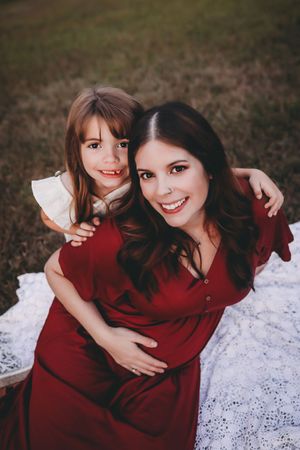 Two people in red outfits sit together on a white blanket outdoors in a series of candid moments.
