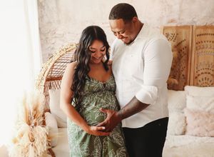A couple in matching white and floral outfits share intimate moments during a romantic indoor photoshoot.