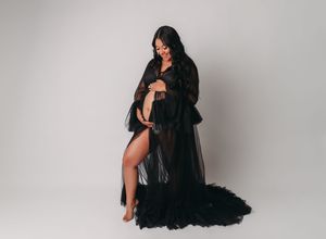 A figure in a flowing black dress poses gracefully against a light gray studio backdrop in multiple artistic shots.