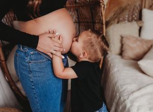 A couple shares an intimate moment in a rustic setting wearing casual denim and neutral colors.