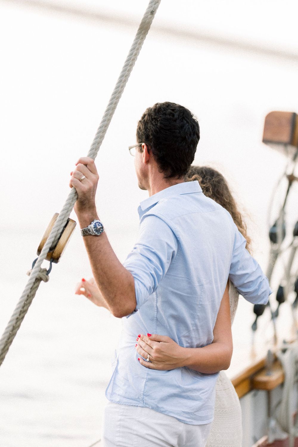 Couple cote à cote sur un bateau, ils regardent tous les deux vers le large, en Martinique