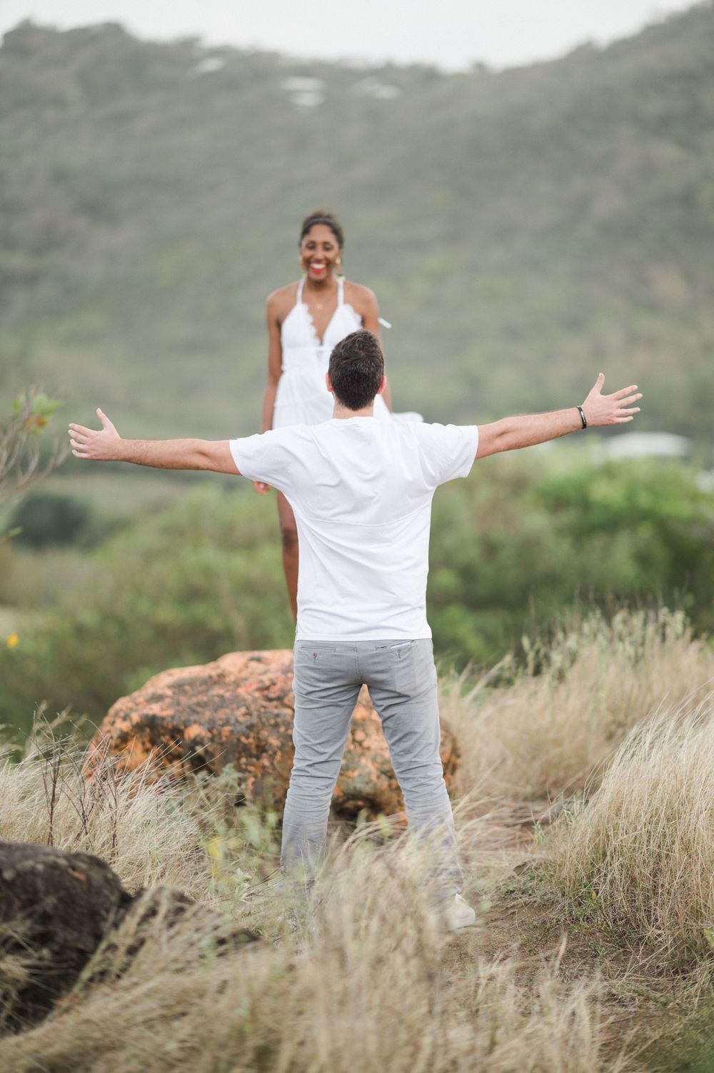 Couple avec l'homme qui tends les bras grands ouverts la femme est sur un rocher en Martinique