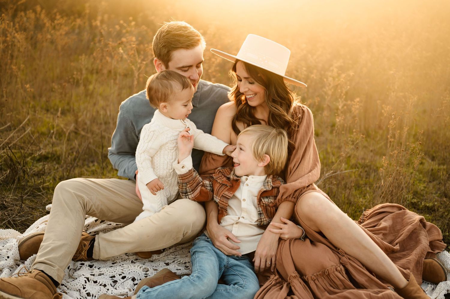 Ojai family photos by Ventura photographer of family sitting in golden grass field cuddling together