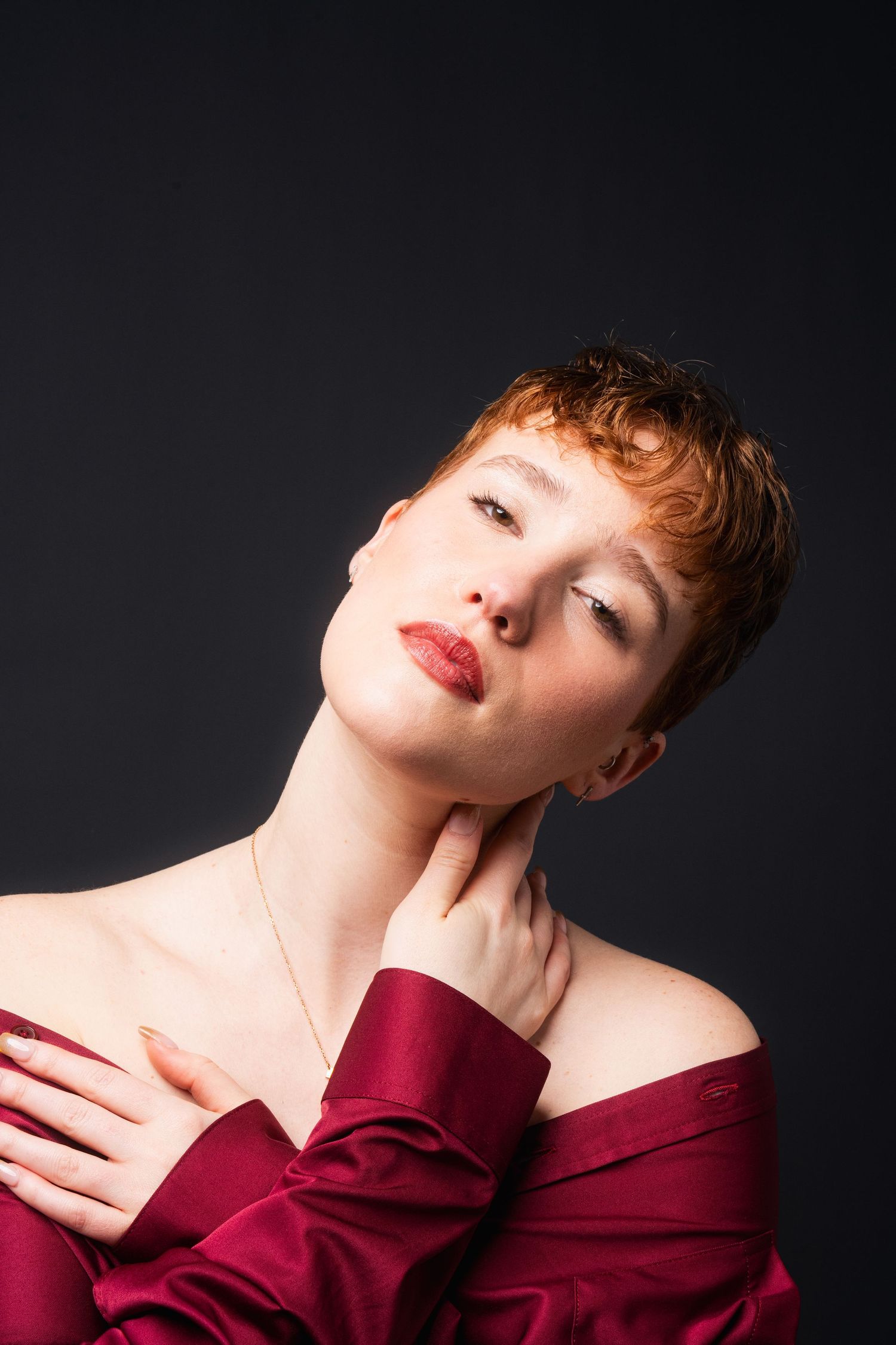 Artistic portrait series featuring dramatic poses in burgundy attire against a dark background.