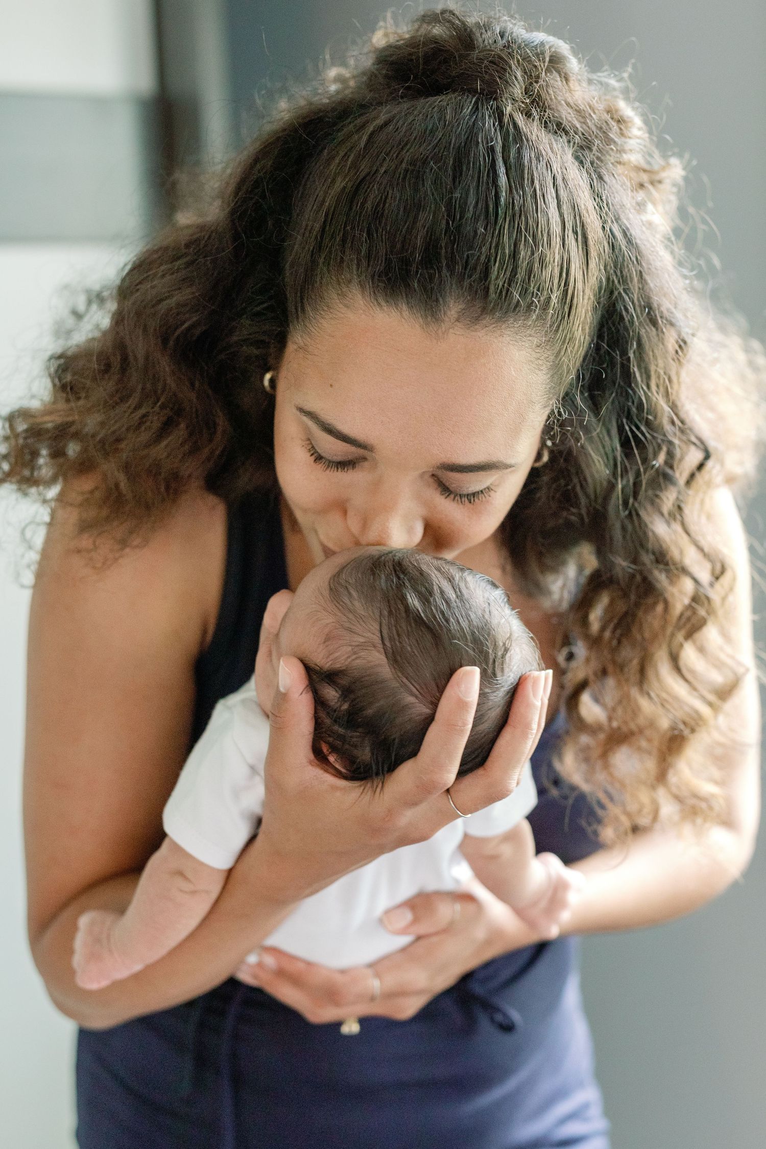 Intimate sequence of a person cuddling with a small cat in a navy blue top.