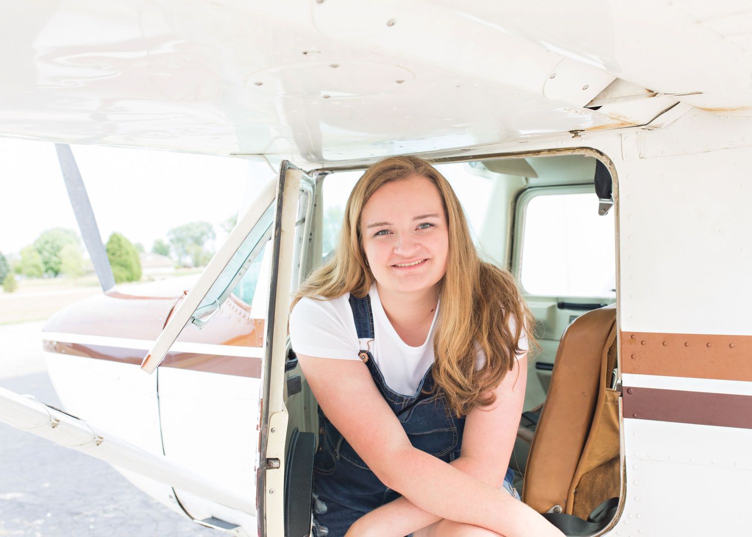High school senior portrait in Appleton WI, featuring a confident, natural pose in a vibrant outdoor setting with timeless style & lighting
