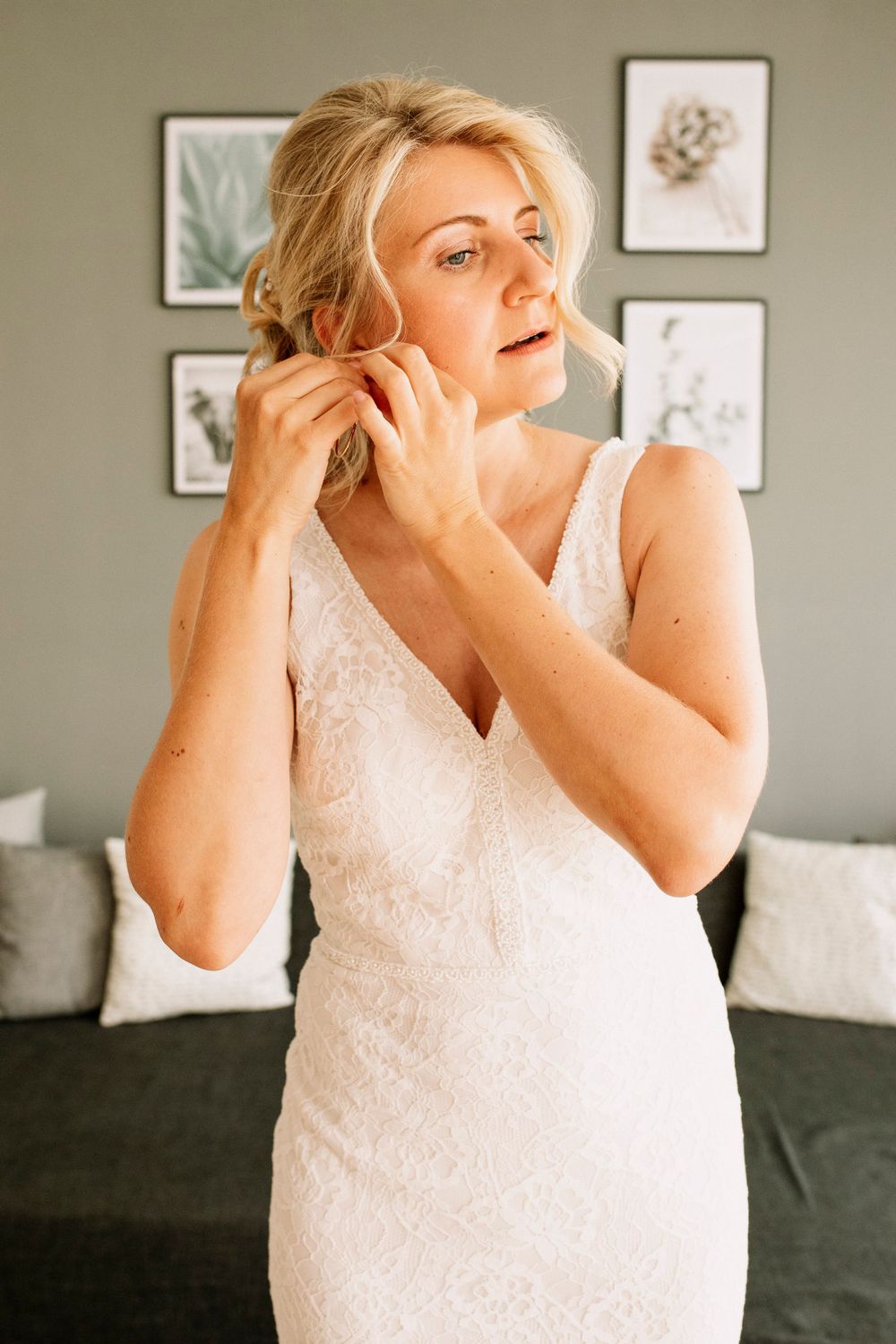 Emotional getting ready moment in a bedroom with soft window light.