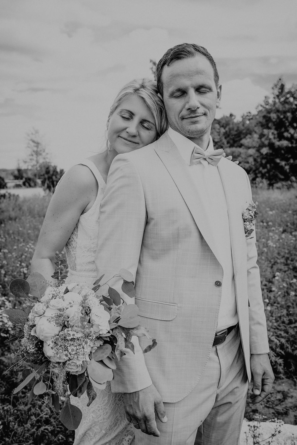 Black and white wedding photos showing couple in light colored attire posing together outdoors.