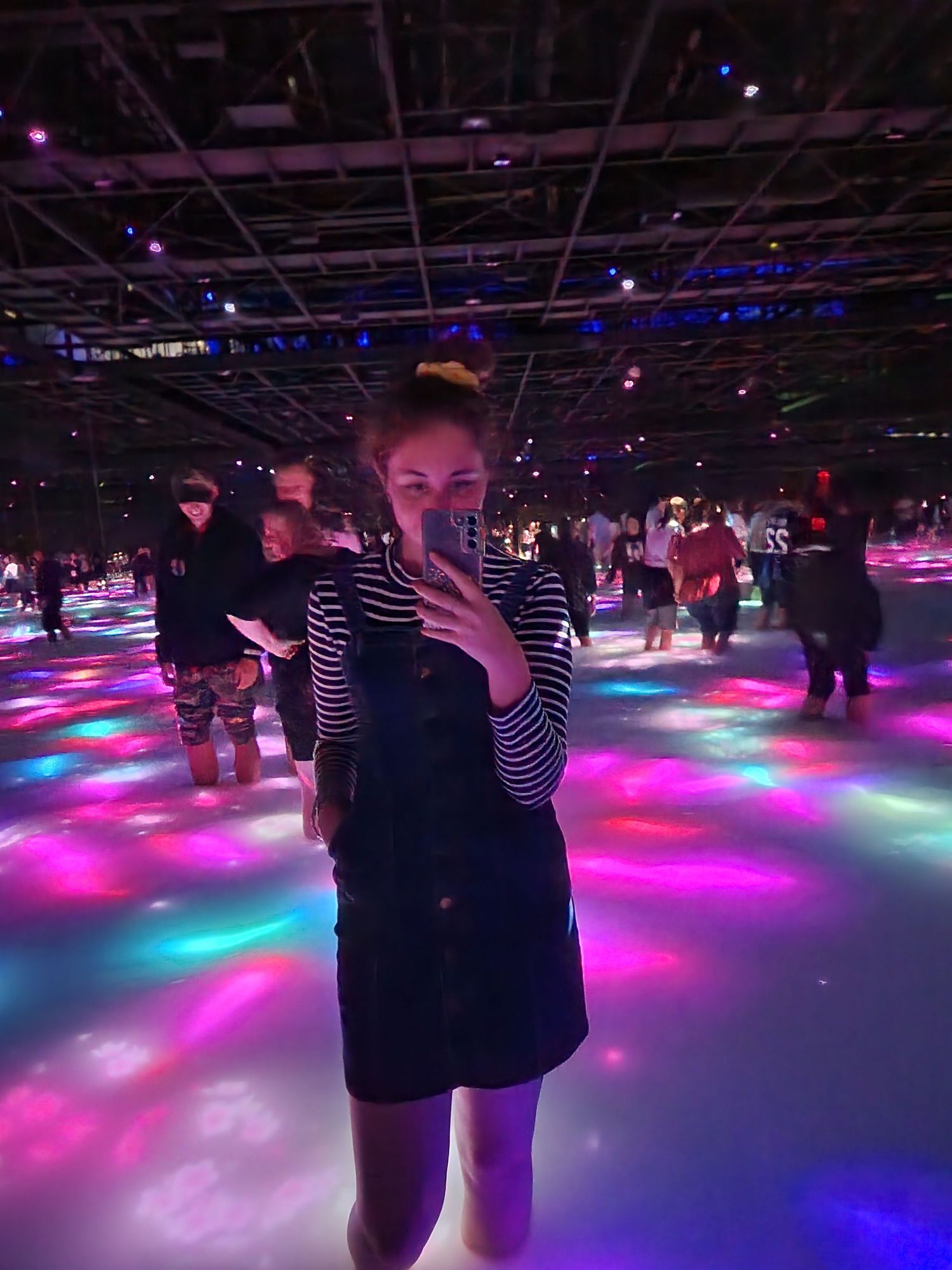 Illuminated dance floor with colorful pink and purple lights creating an immersive atmosphere.