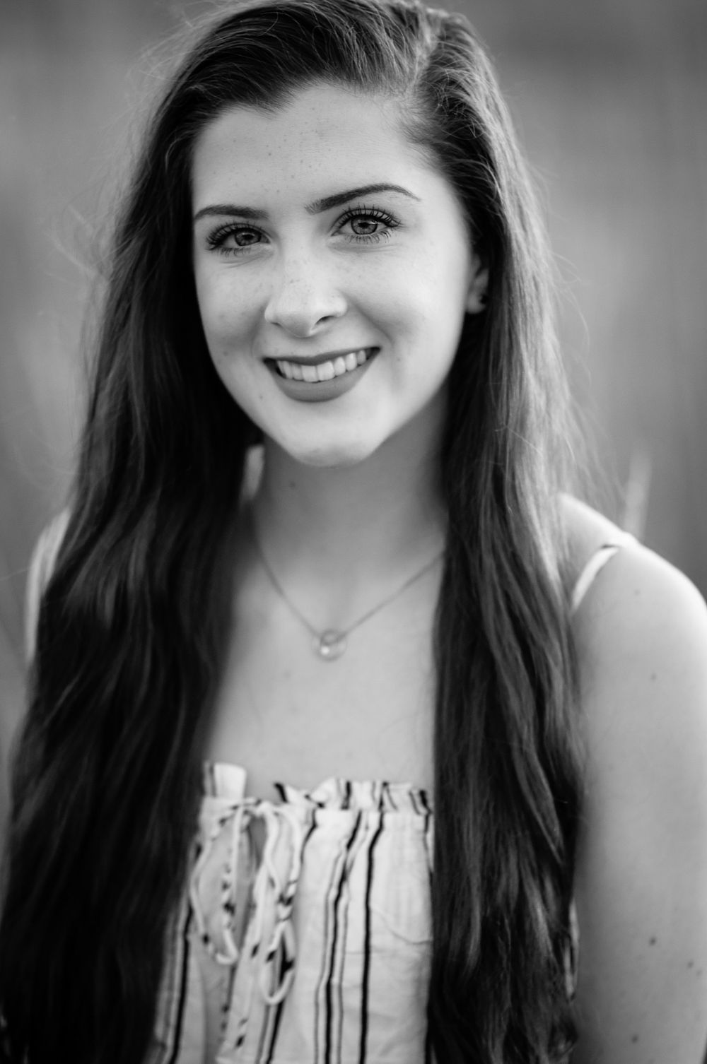 A portrait of a teen girl in black and white wearing a striped top