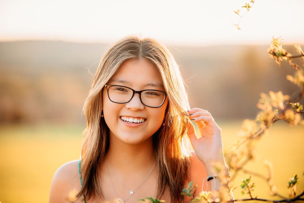 high school senior smiling in natural light during outdoor portrait session