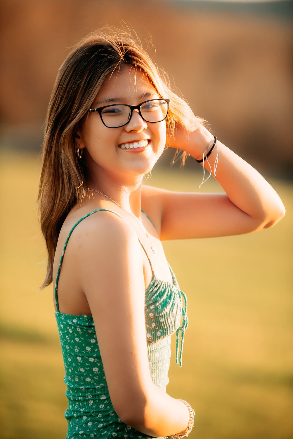high school senior smiling in golden light during outdoor portrait session