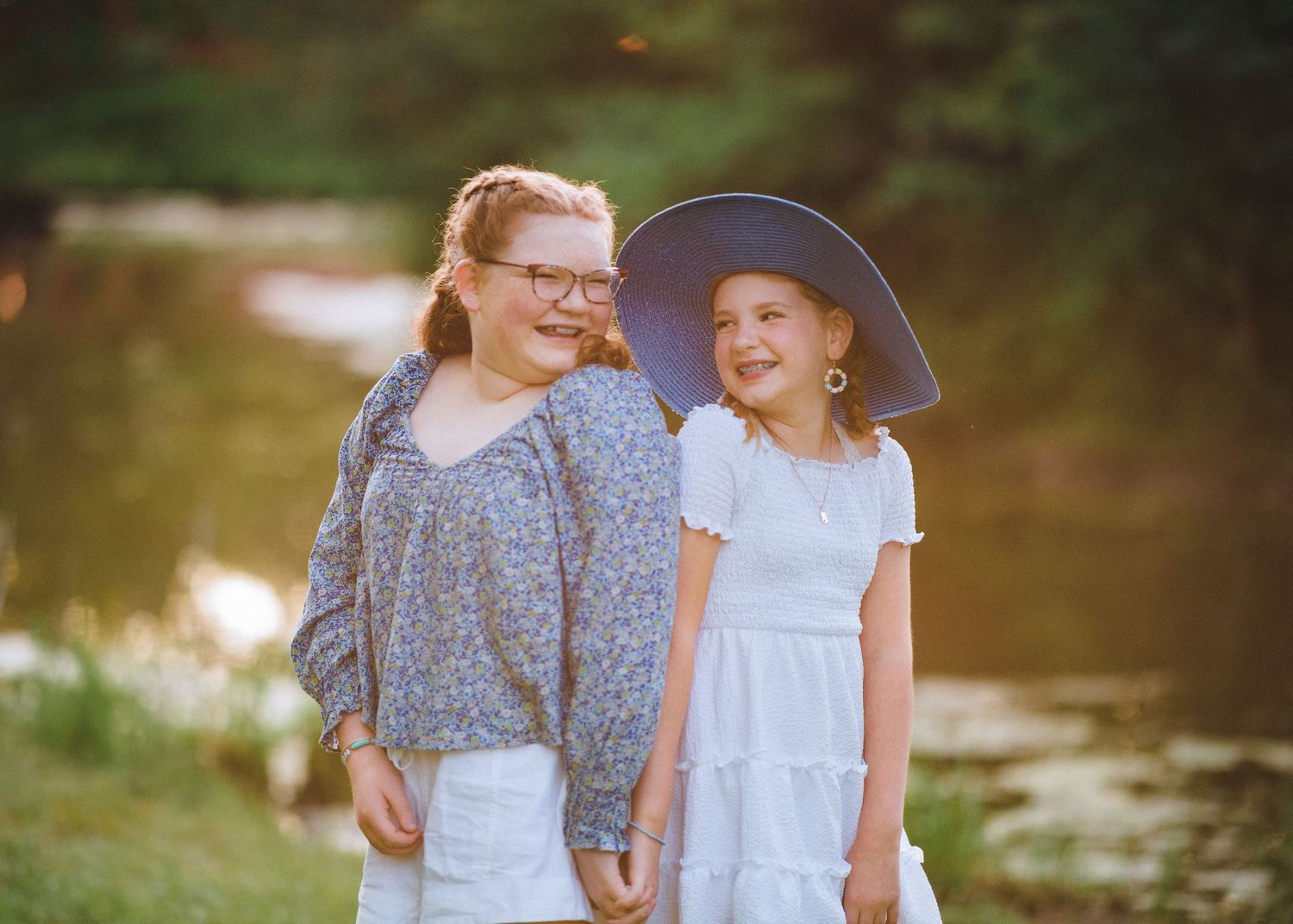 Natural image of sisters laughing near water
