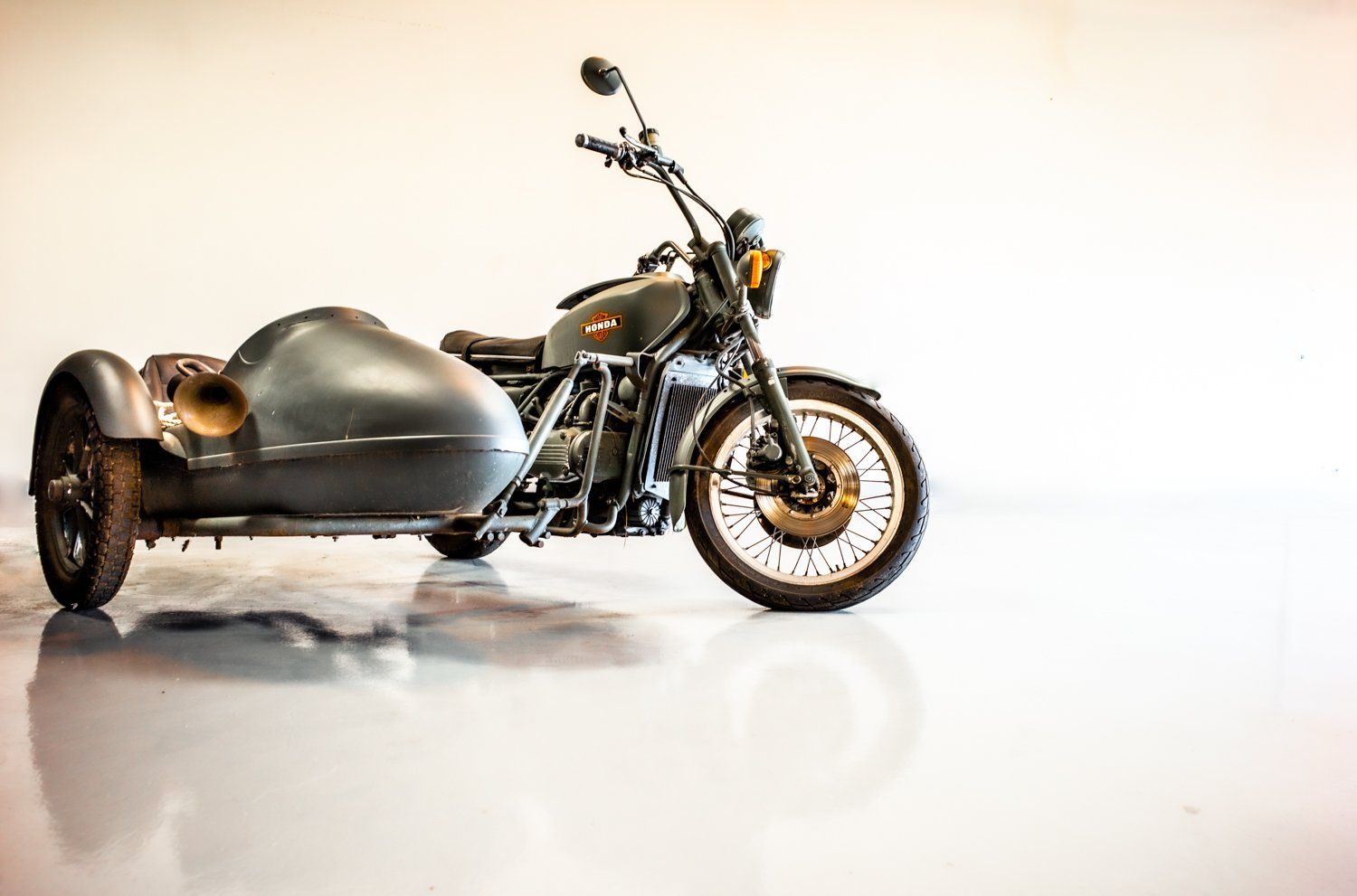 Silver vintage motorcycle with sidecar photographed against white background in studio lighting.