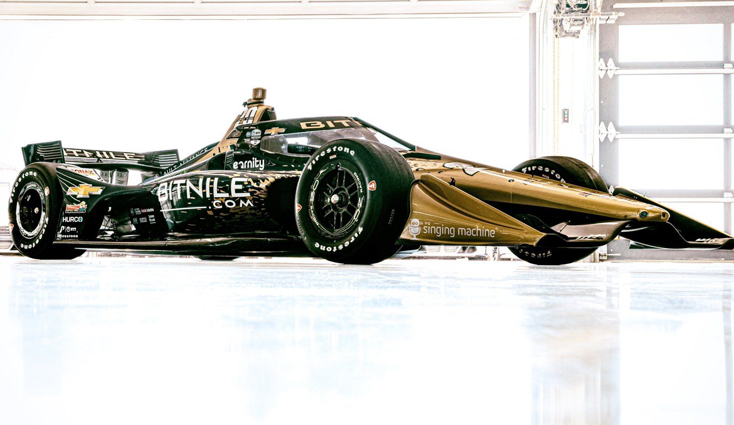 Gold and black Formula 1 race car photographed in bright studio setting.