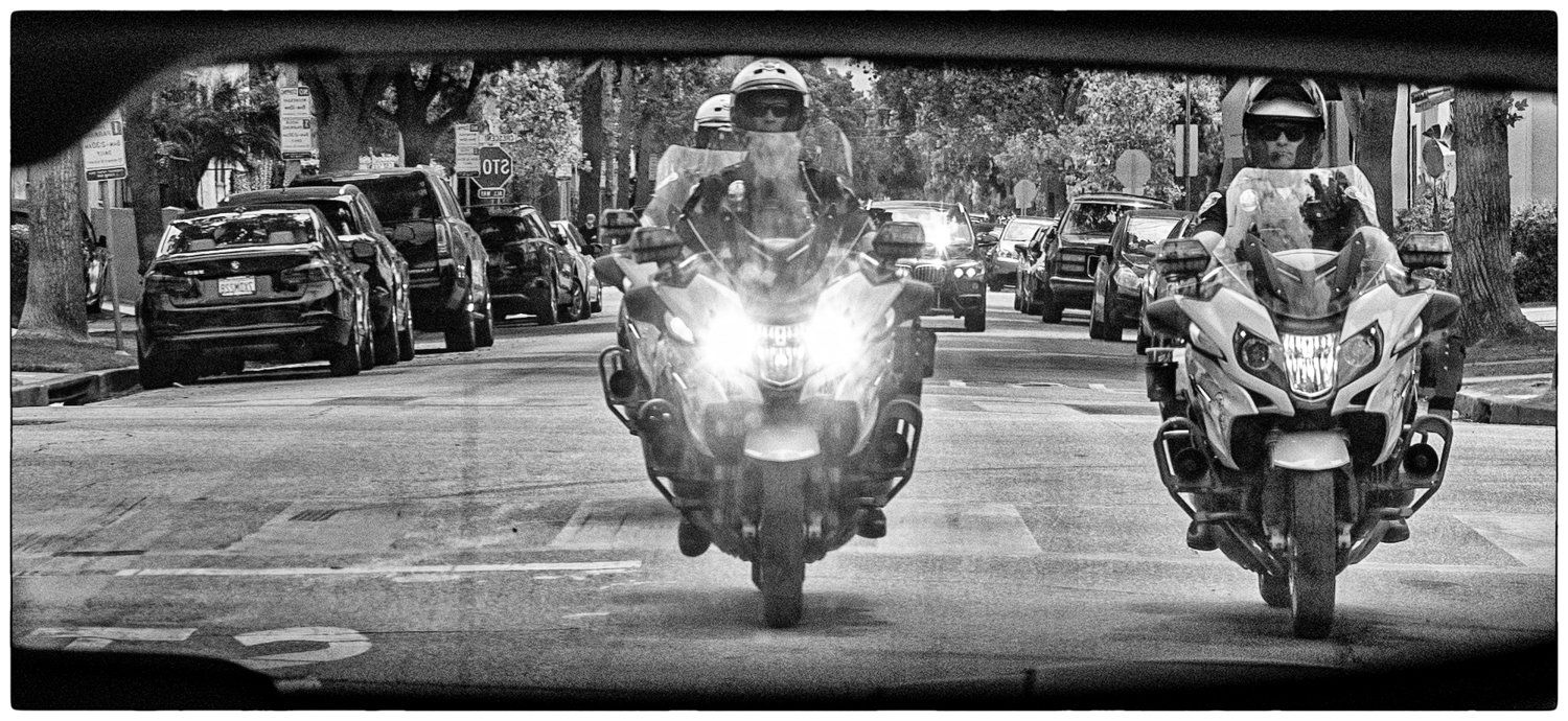 Three motorcycles riding in formation on a city street in black and white.
BLM