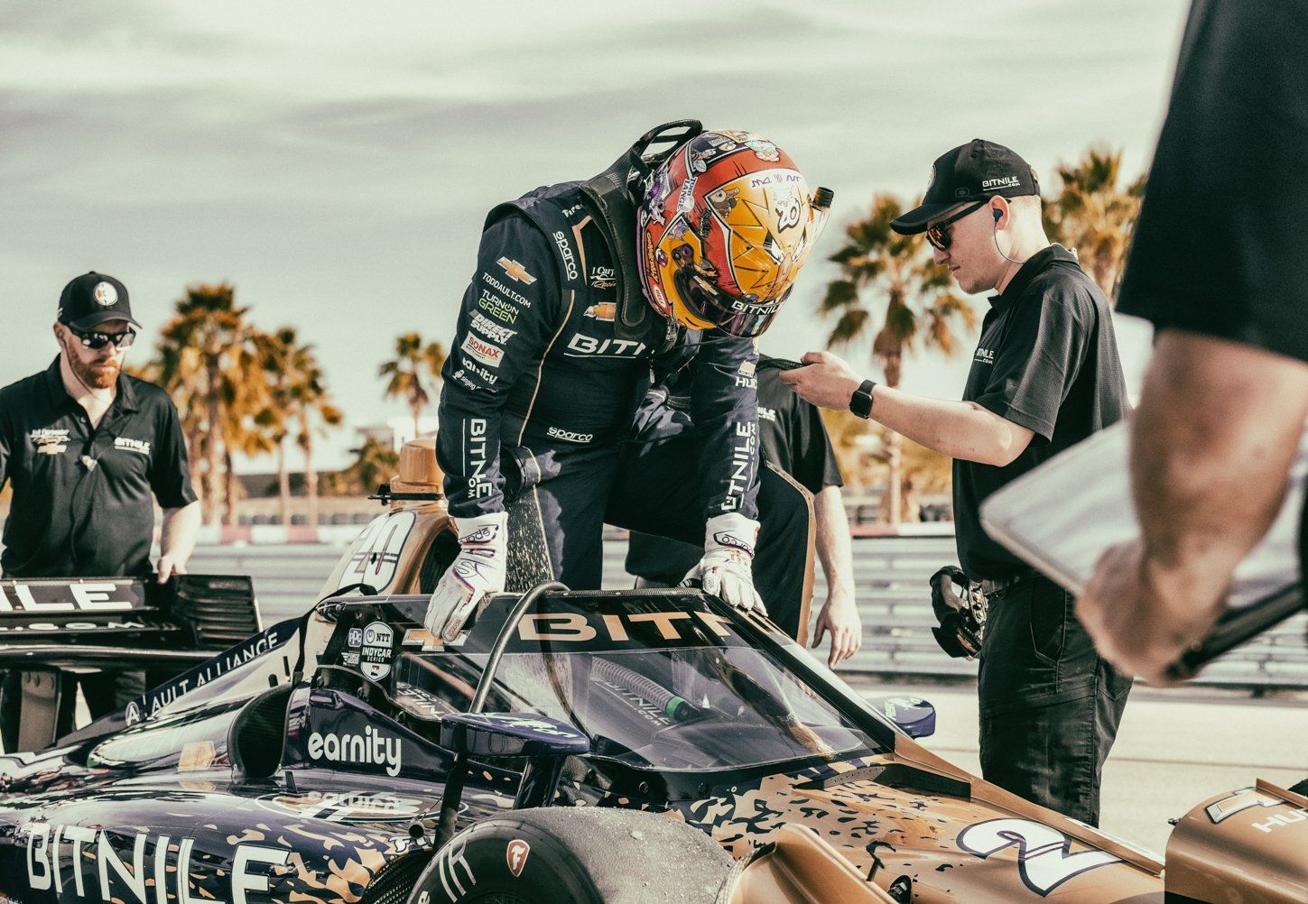 Racing team members working on a race car during a pit stop.
