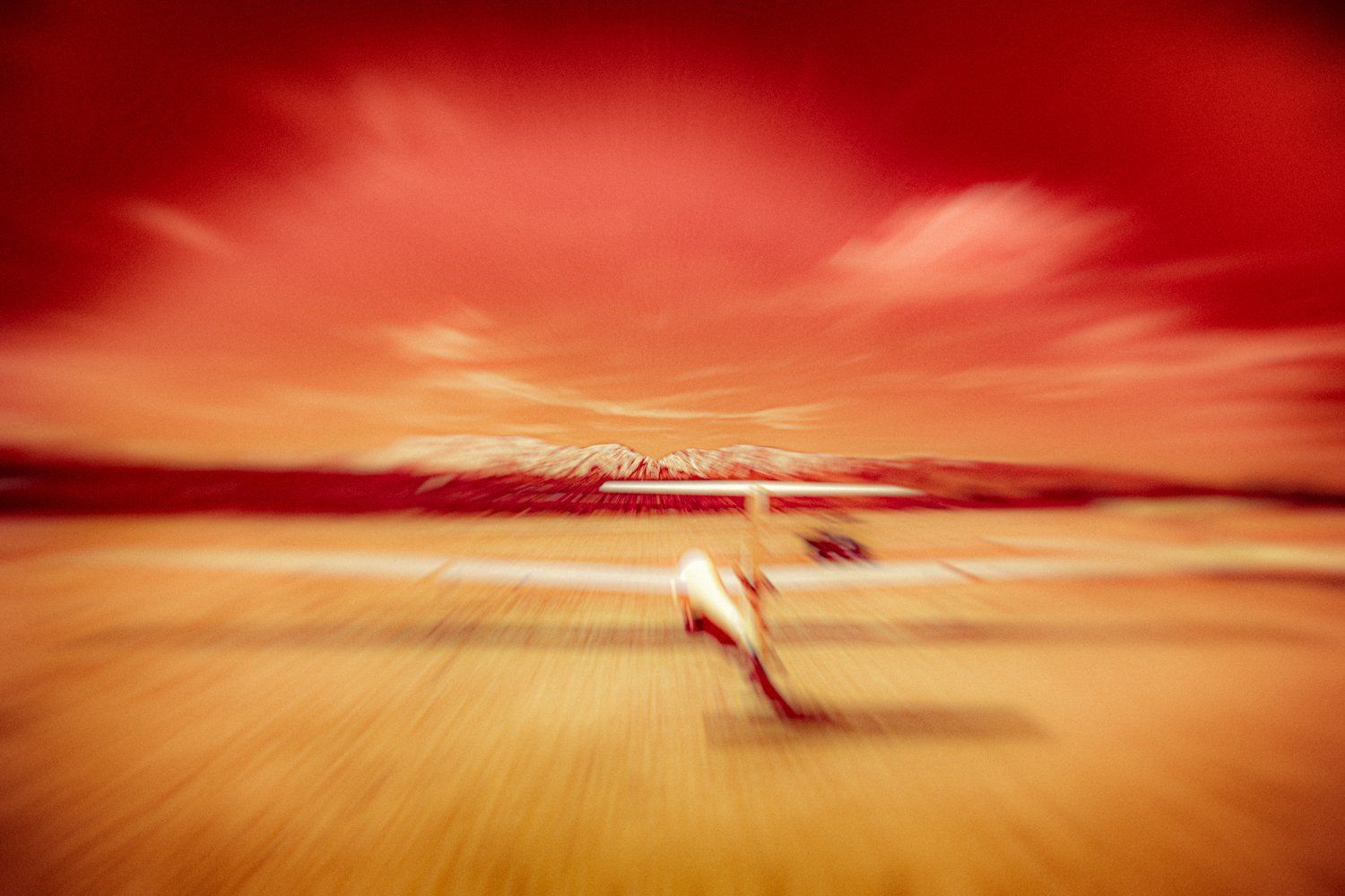 Abstract motion blur photo of a beach scene with red sunset sky.