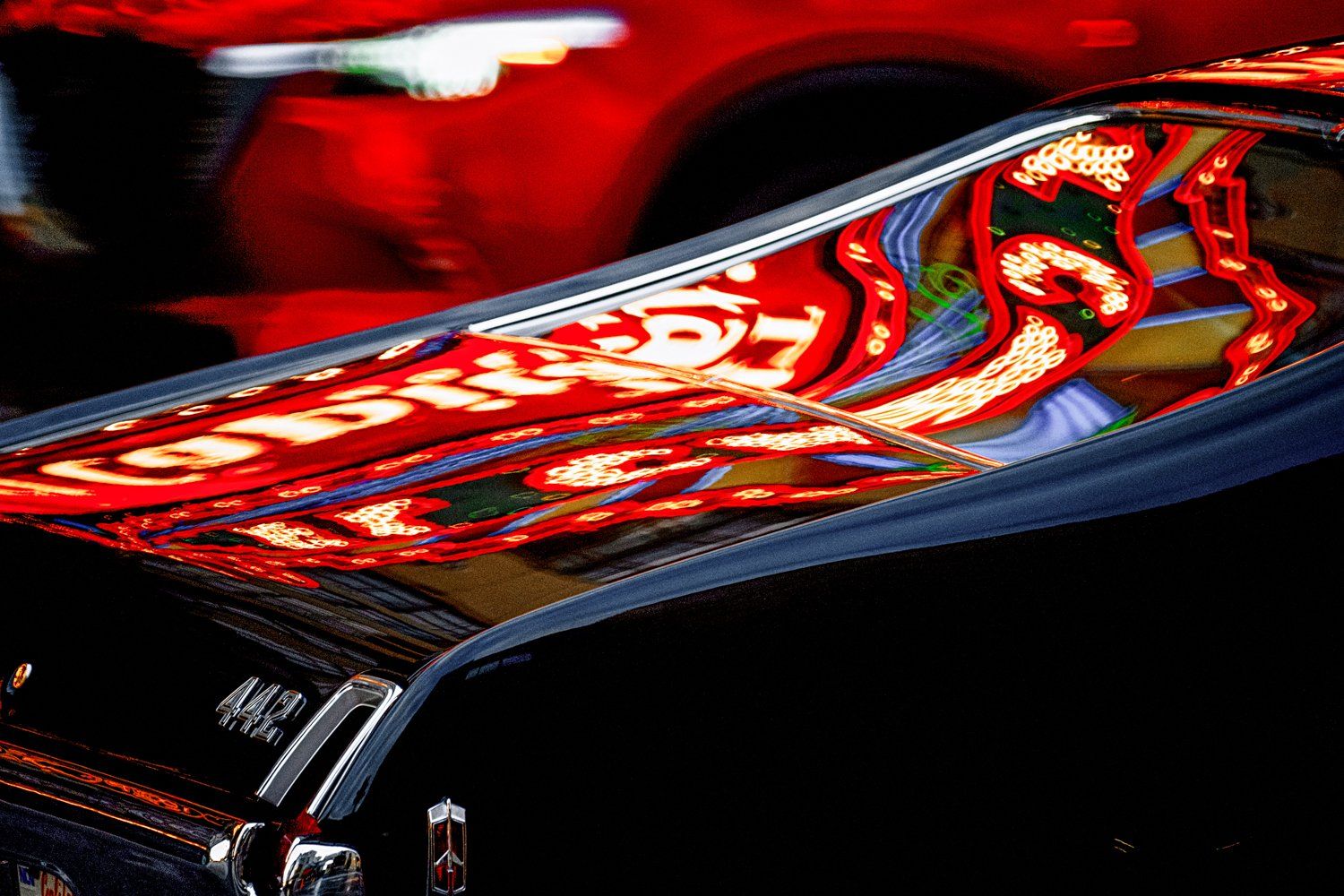 Abstract reflection of red sports car showing vibrant curves and lines.