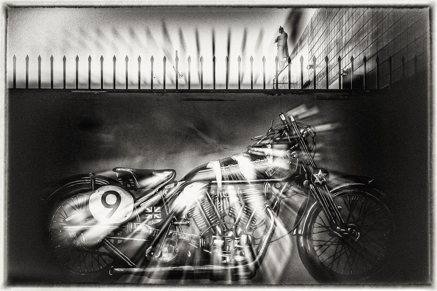 Black and white artistic photograph of vintage motorcycles with dramatic lighting effects.