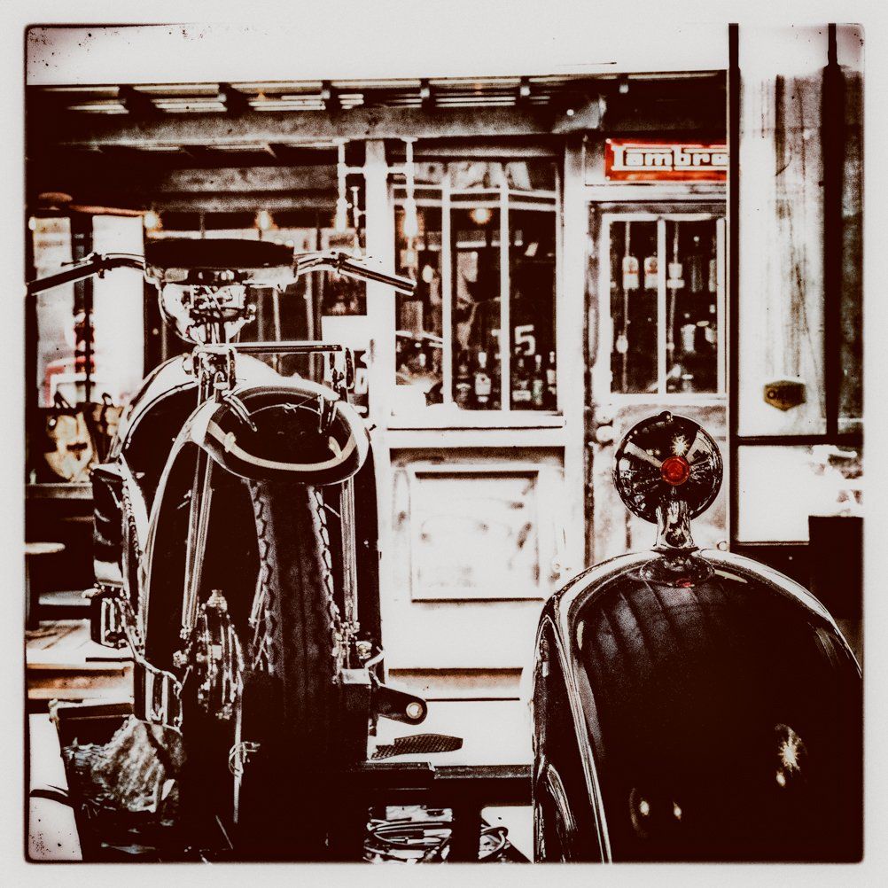 Black and white image of a classic barbershop exterior with vintage styling chairs.