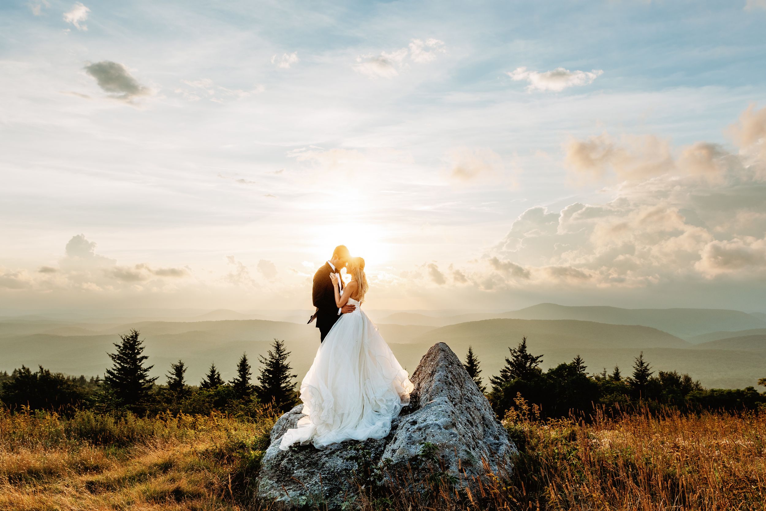 a bride and groom bask in the warm sunset light on top of Spruce Knob mountain in West Virginia for their elopement.
