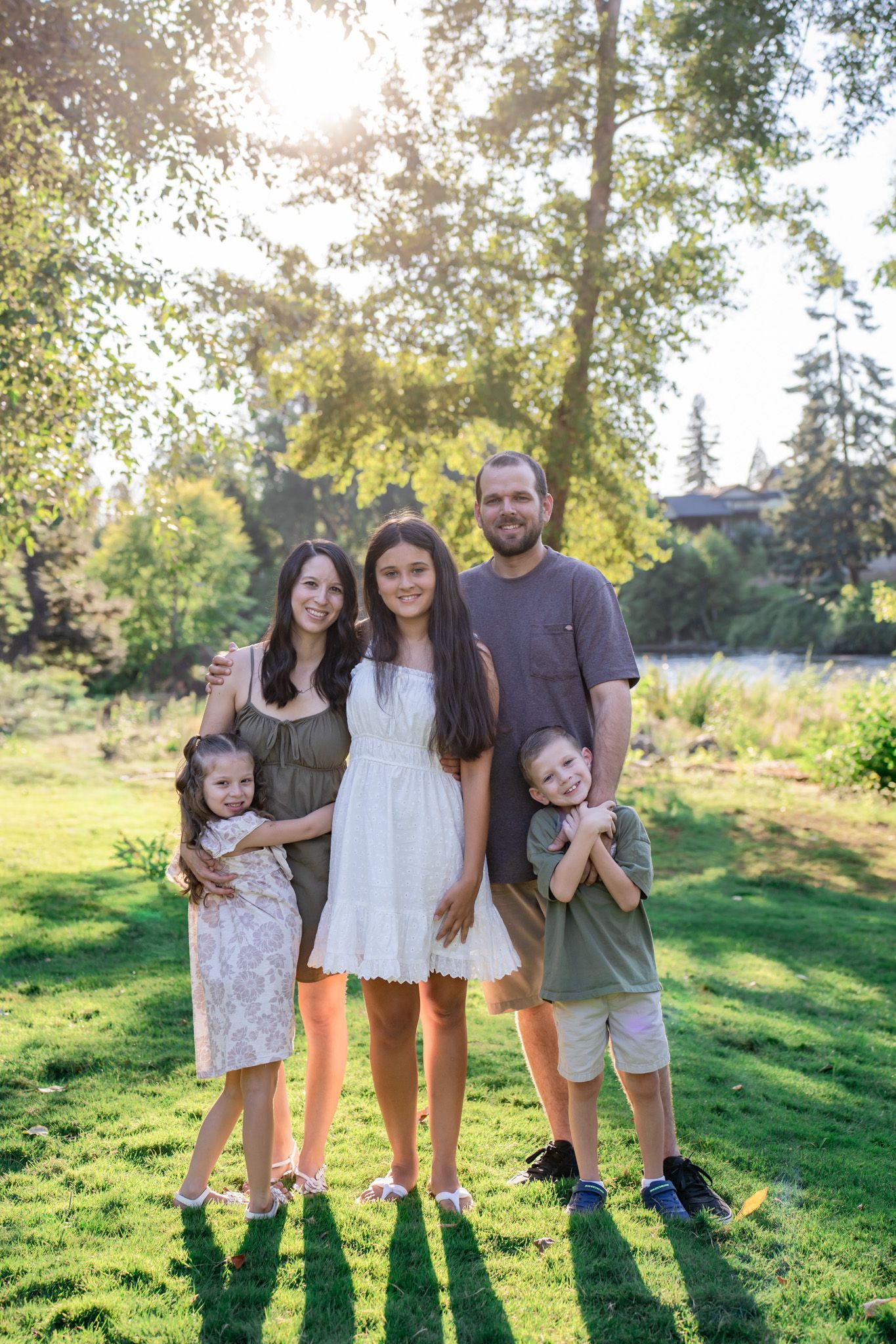 family portrait in a grassy field by the Rogue River at Rogue River Resort