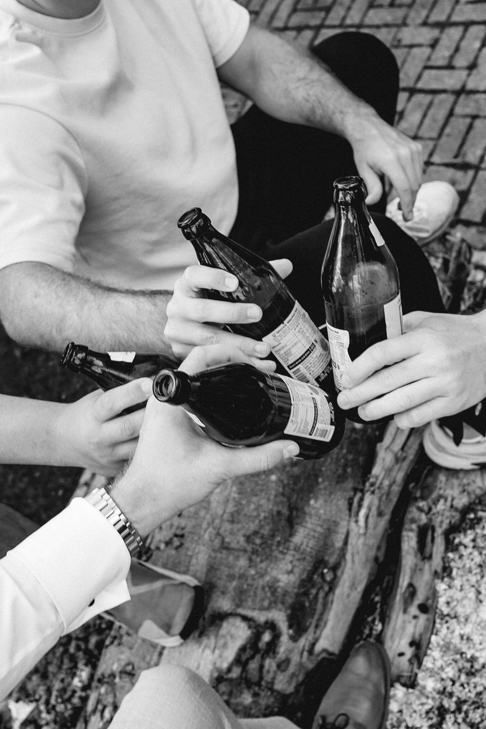 A sequence of black and white photos showing hands pouring and handling wine bottles and glasses.