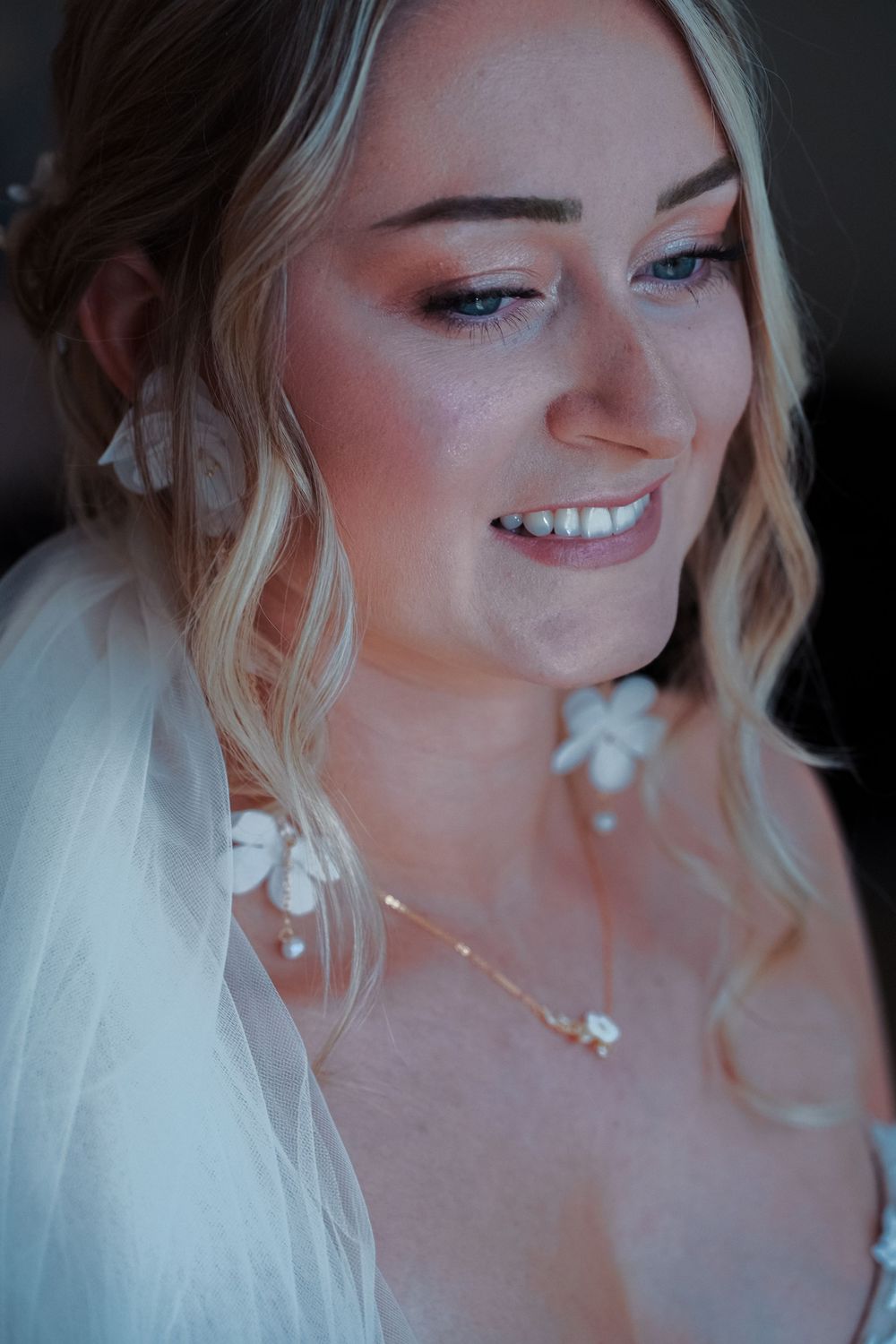 A sequence of photos showing a bride smiling and laughing in soft lighting while wearing a white veil.