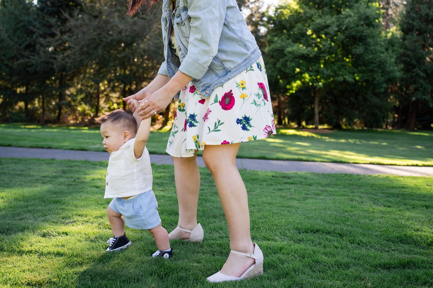 Child learning how to walk while holding onto mom