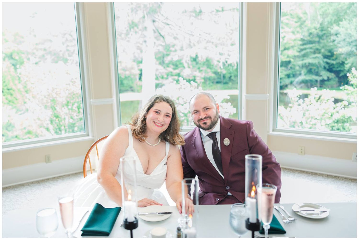 Bride and groom seated together at their sweetheart table during wedding reception.