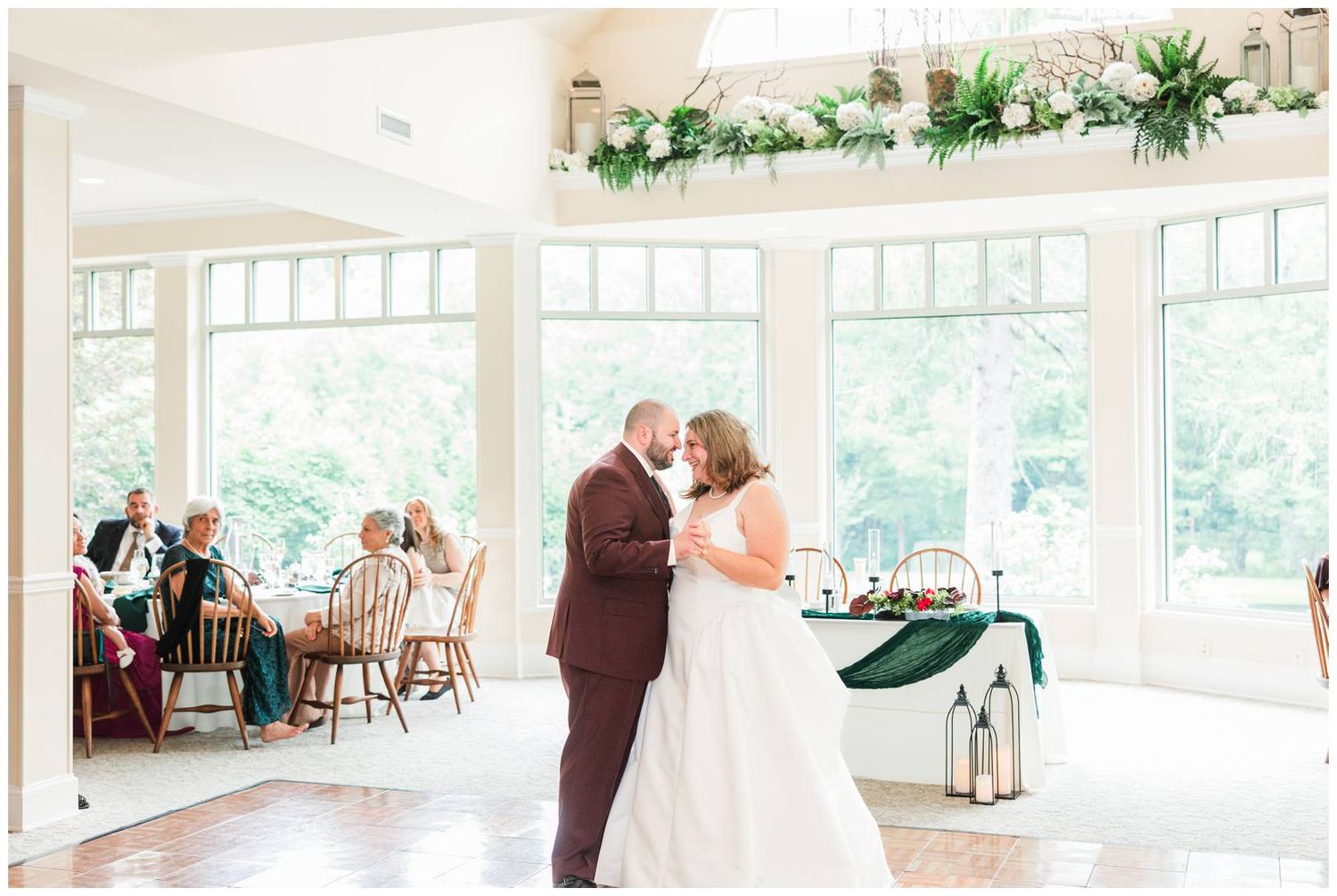 Bride and groom sharing romantic first dance in bright sunlit wedding reception venue.