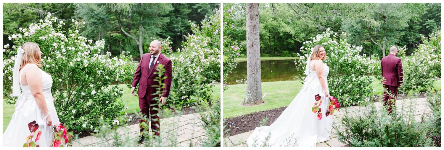 Bride and groom share a romantic first look moment surrounded by lush green gardens and white blooms.