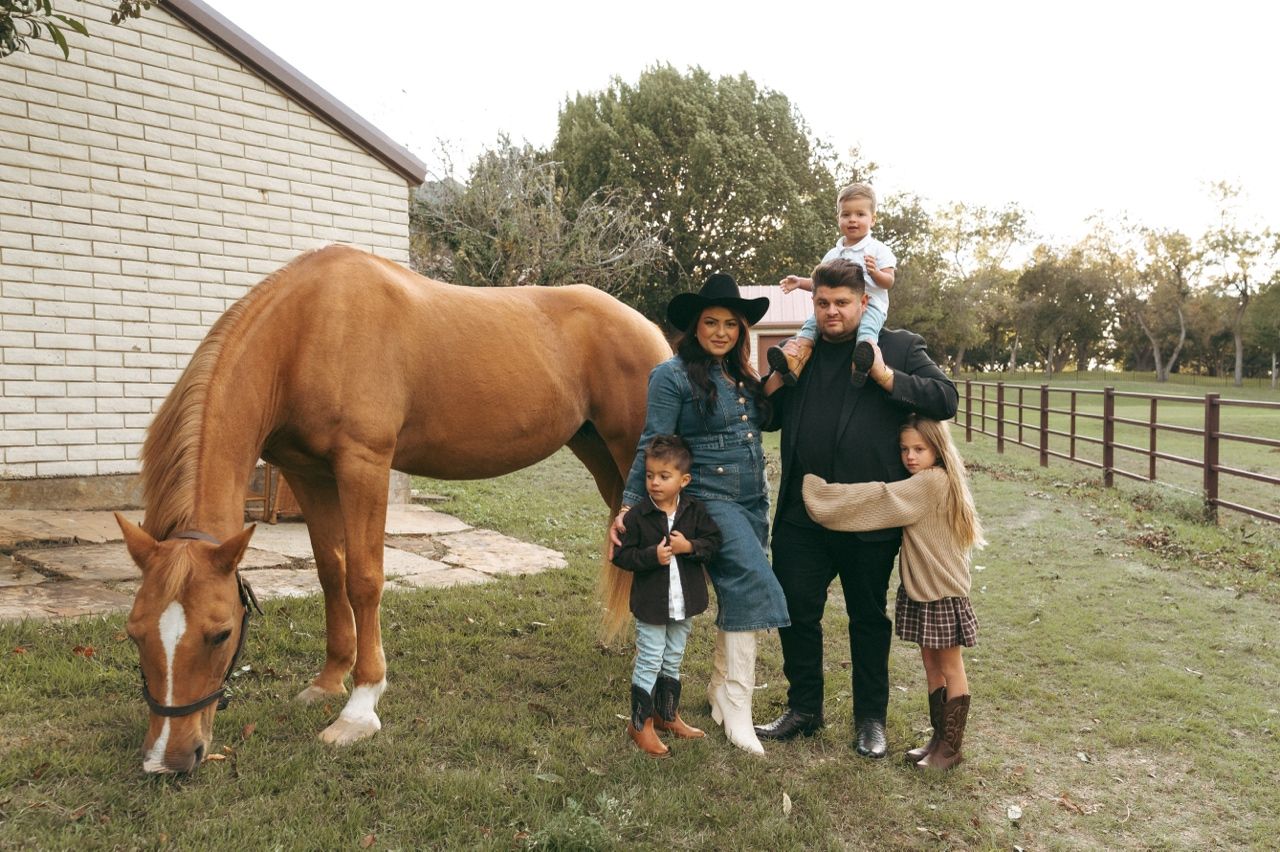 Family of five poses beside a brown horse on the property of Windmill Stables in Richardson TX.