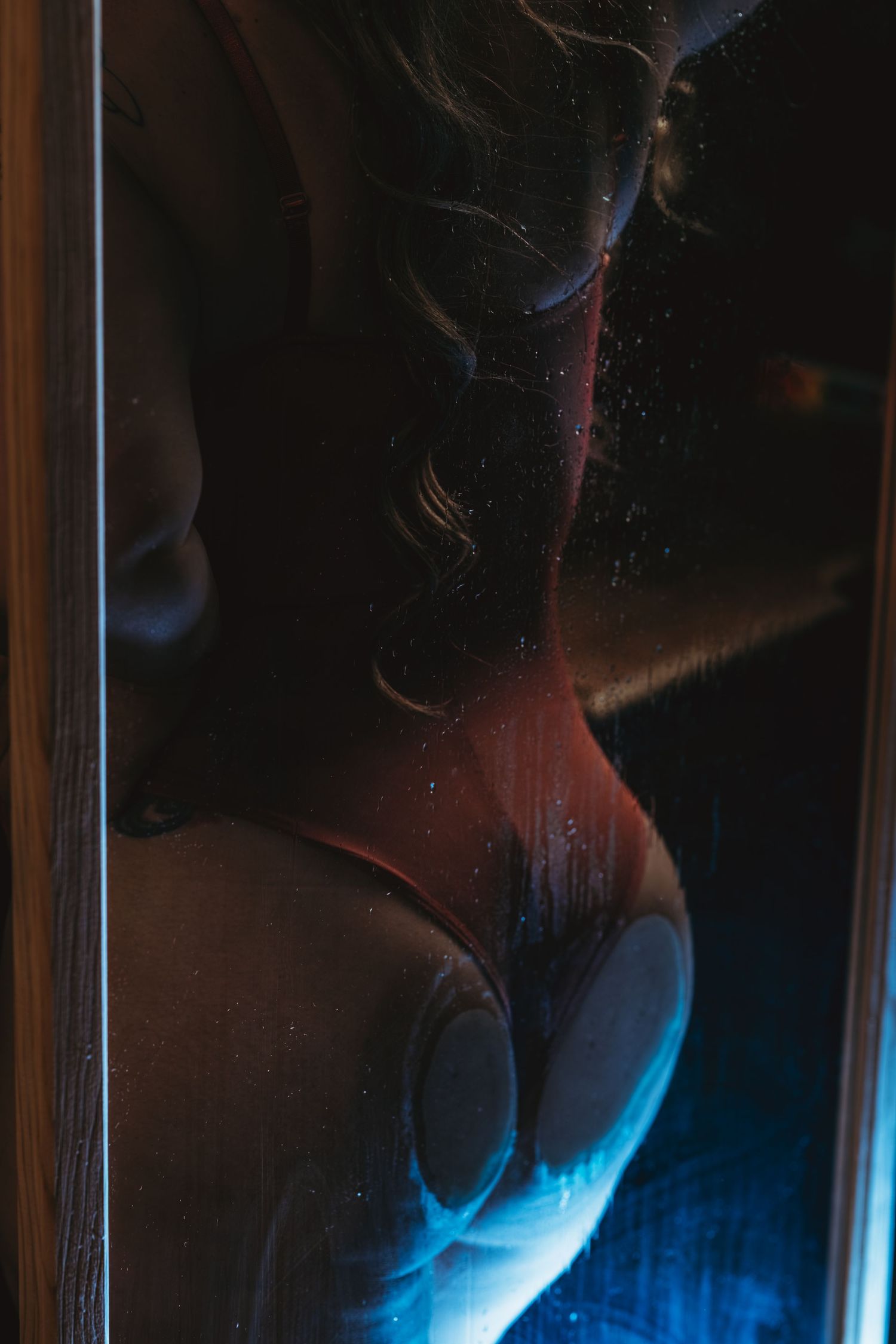 Artistic shot of an intimate moment in romantic lighting with red strawberry and polka dot patterns. Boudoir Photographer Grand Rapids,  MI
