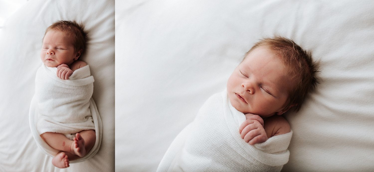 Peaceful newborn baby swaddled in white wrap sleeping on white blanket in professional newborn photography session.