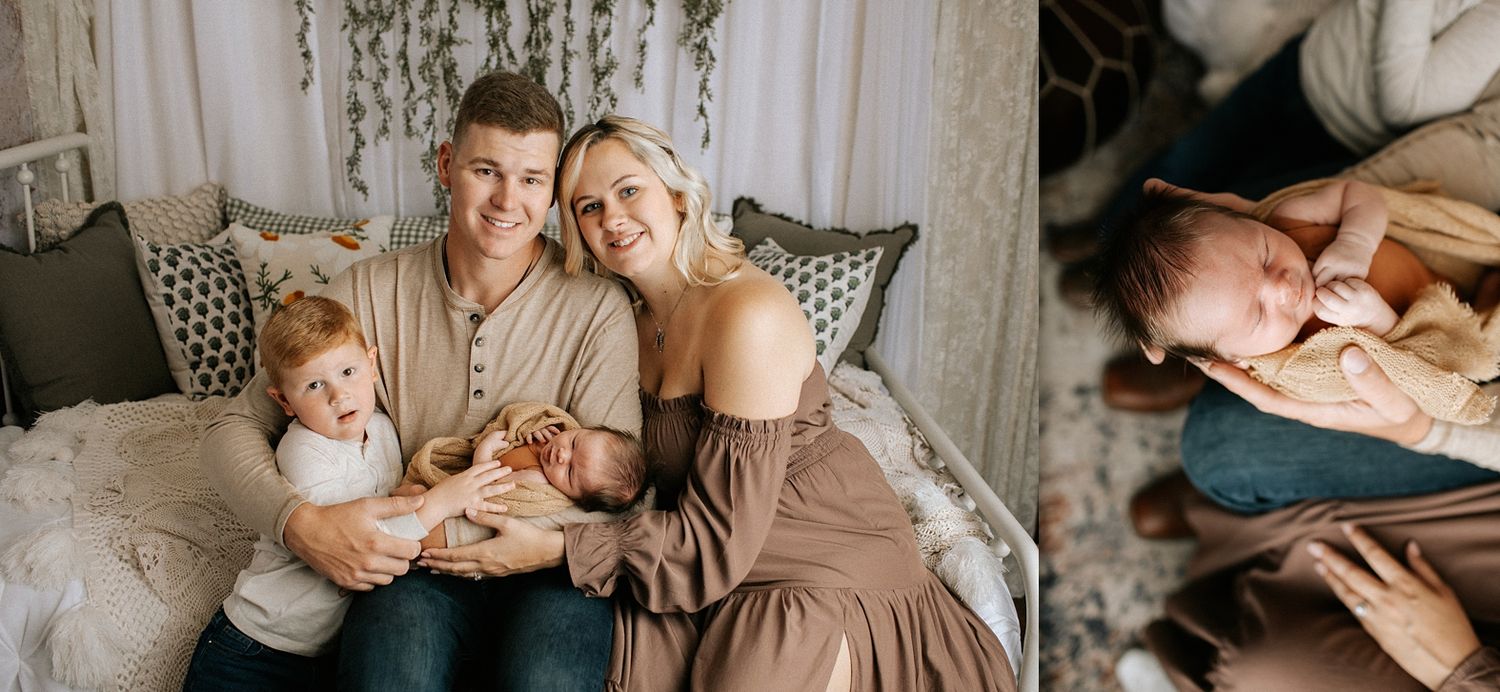 A happy family with a toddler and newborn baby poses for a warm, intimate newborn photography session indoors.